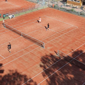 tennisbaan met bruine baan en tennissers