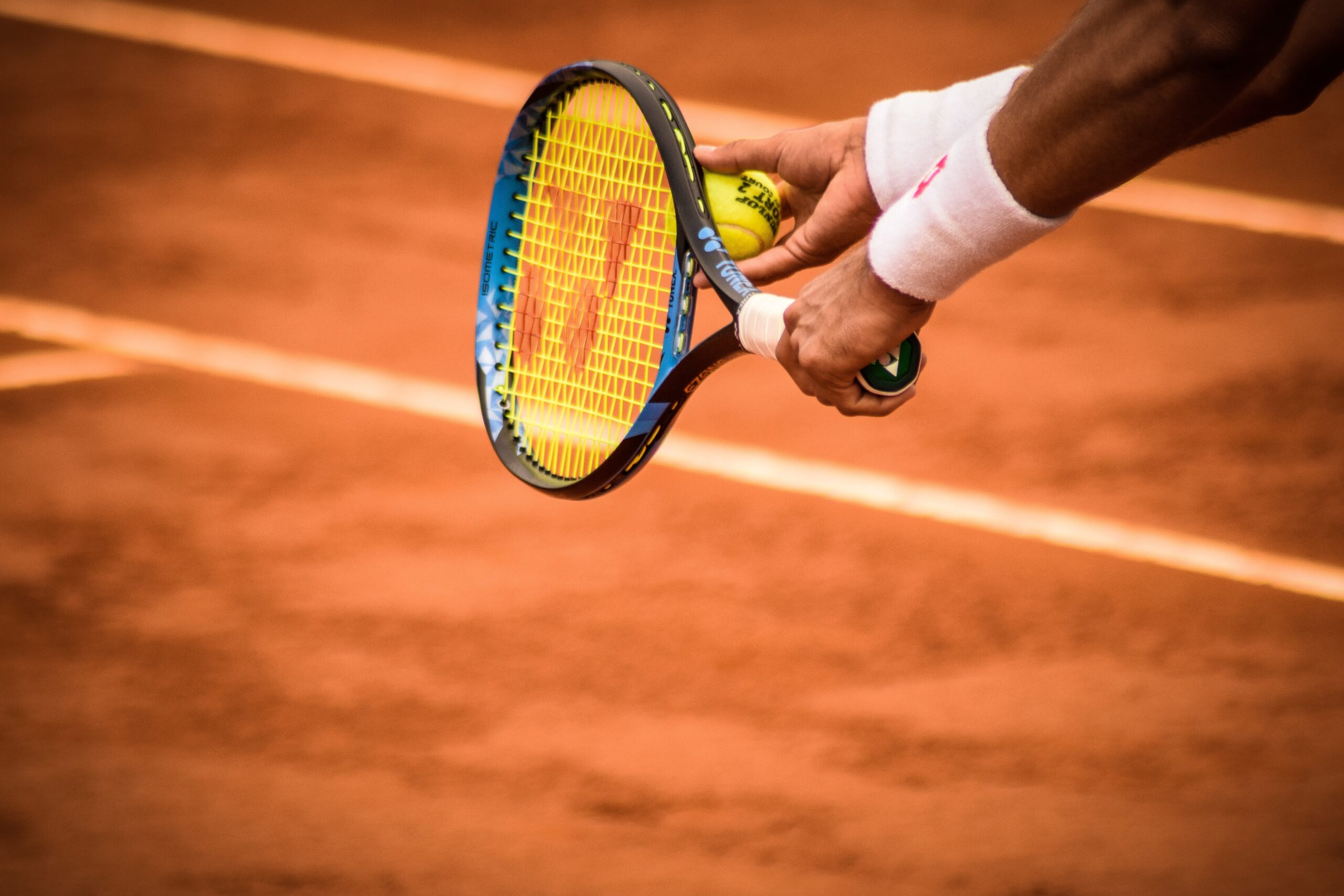 Tennisser houd tennisracket horizontaal met tennisbal ertegen aan.